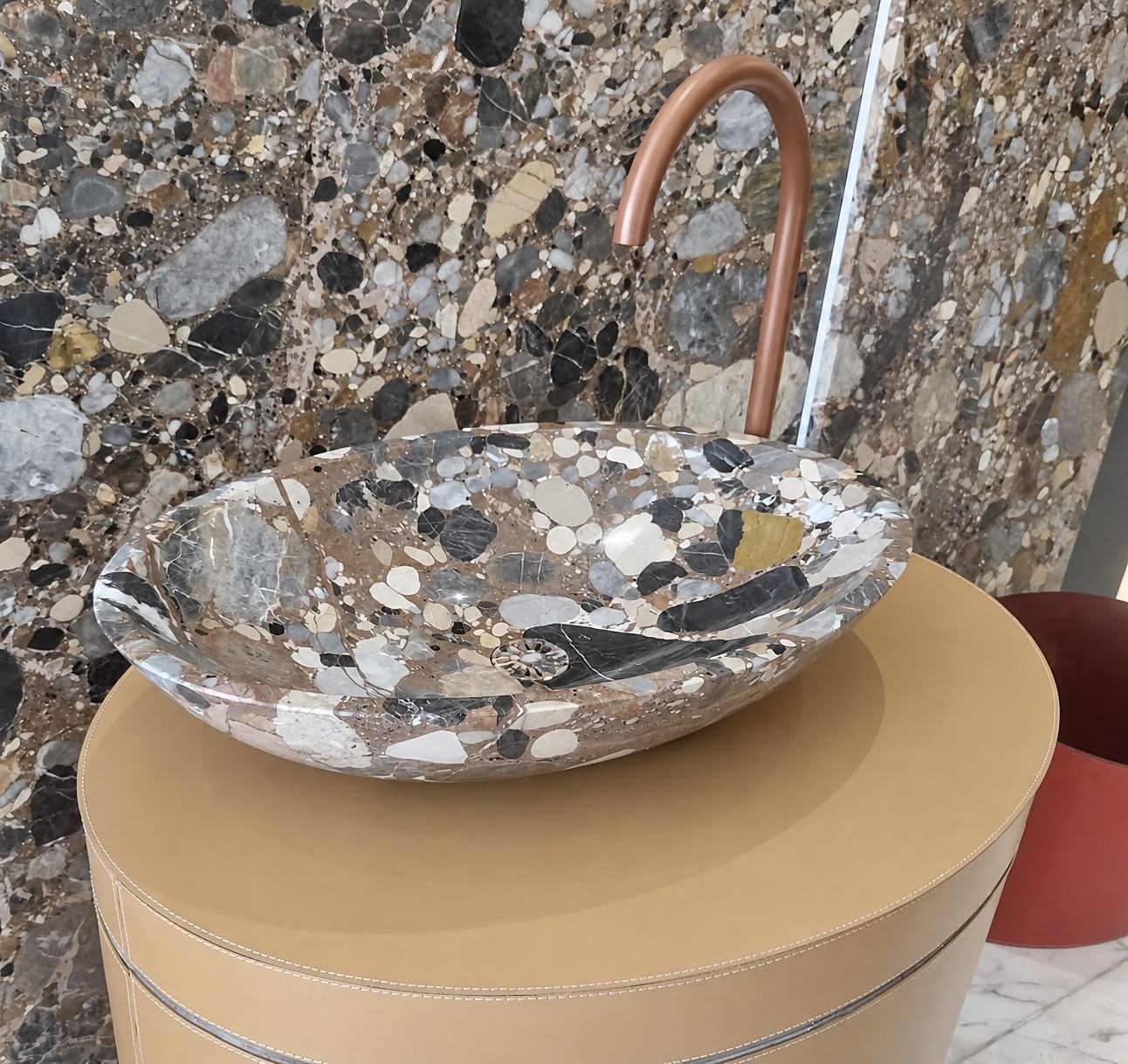 Dettaglio lavabo in breccia con rubinetto a collo di cigno