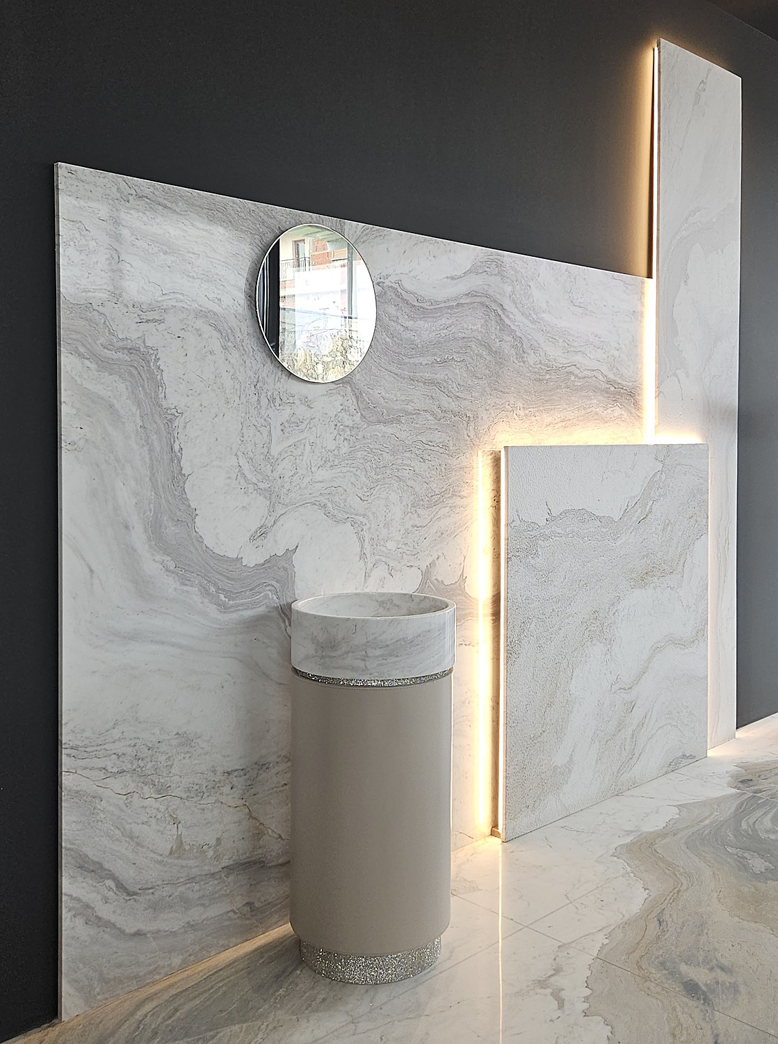 Parete in marmo a spigolo con specchio e lavabo a colonna