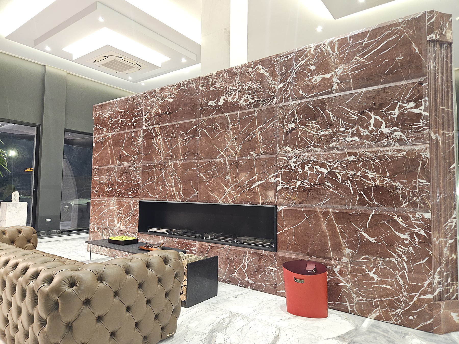 Lounge con divano e camino in marmo rosso