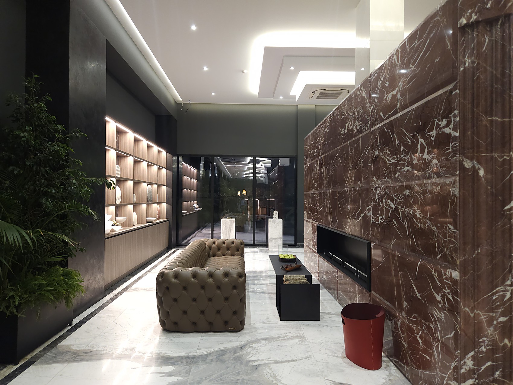 Corridoio showroom con pareti in marmo e salotto
